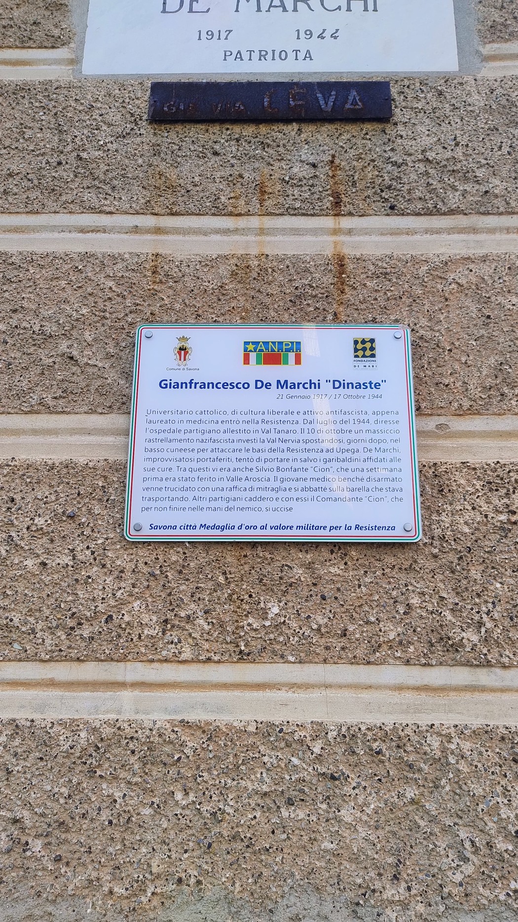 Targa in onore di Gianfrancesco De Marchi, patriota, affissa su una parete di pietra.