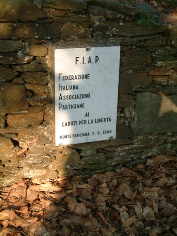 Lapide dedicata ai caduti per la libertà nel Parco della Resistenza del Monte Brugiana, immerso nella natura.