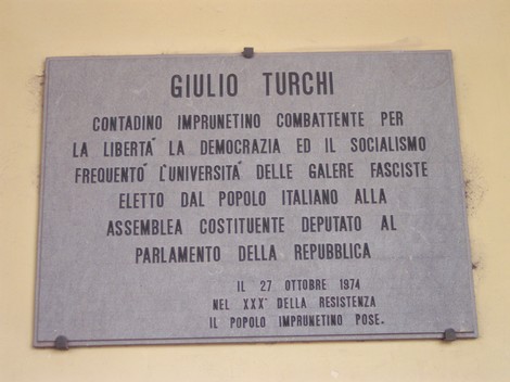 Lapide commemorativa dedicata a Giulio Turchi, attivista per la libertà e la democrazia, situata in Italia.