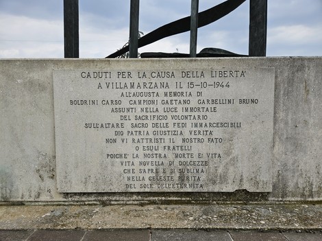 Monumento ai Caduti di Runzi, con iscrizioni che commemorano il sacrificio per la libertà e la giustizia.