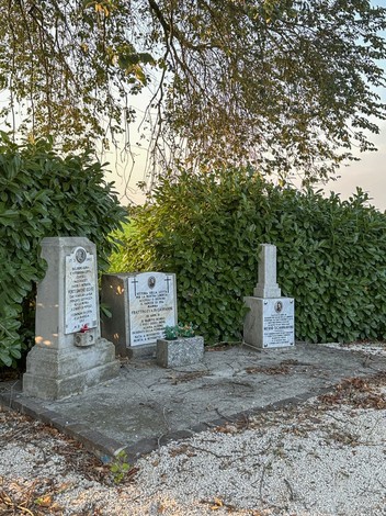 Cippi funerari di Forti, Frattini e Scannavini, immersi nella vegetazione, evocano un senso di memoria e rispetto.