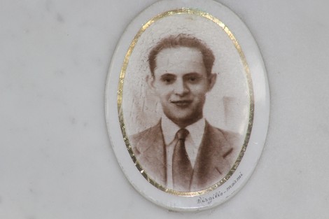 Ritratto di un uomo in abito formale, incorniciato, parte del monumento ai caduti per la Liberazione.