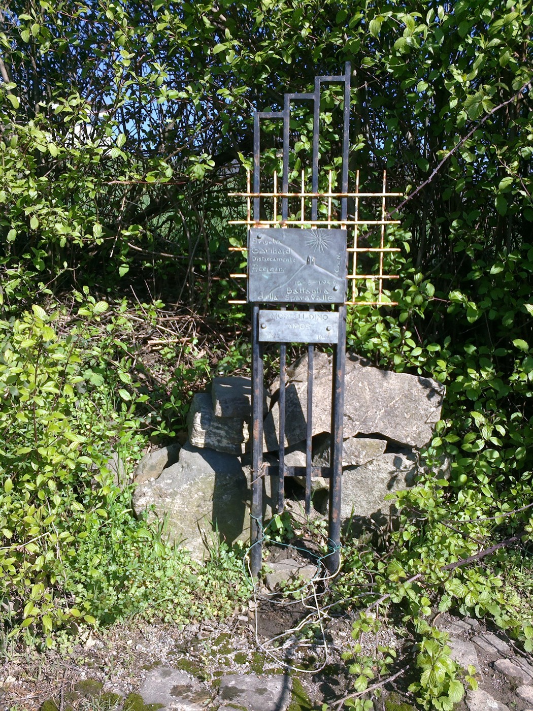 Monumento a Morelli, un'opera in mezzo alla natura, circondata da vegetazione e pietre.