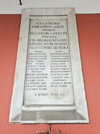 Lapide commemorativa dedicata ai caduti della guerra 1940-45 con nomi di eroi scritti su pietra.