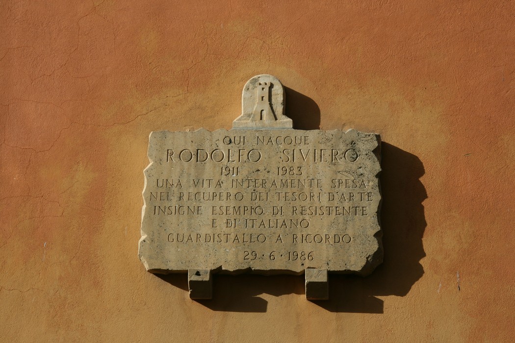 Lapide commemorativa dedicata a Rodolfo Siviero, restauratore e resistente, affissa su un muro.