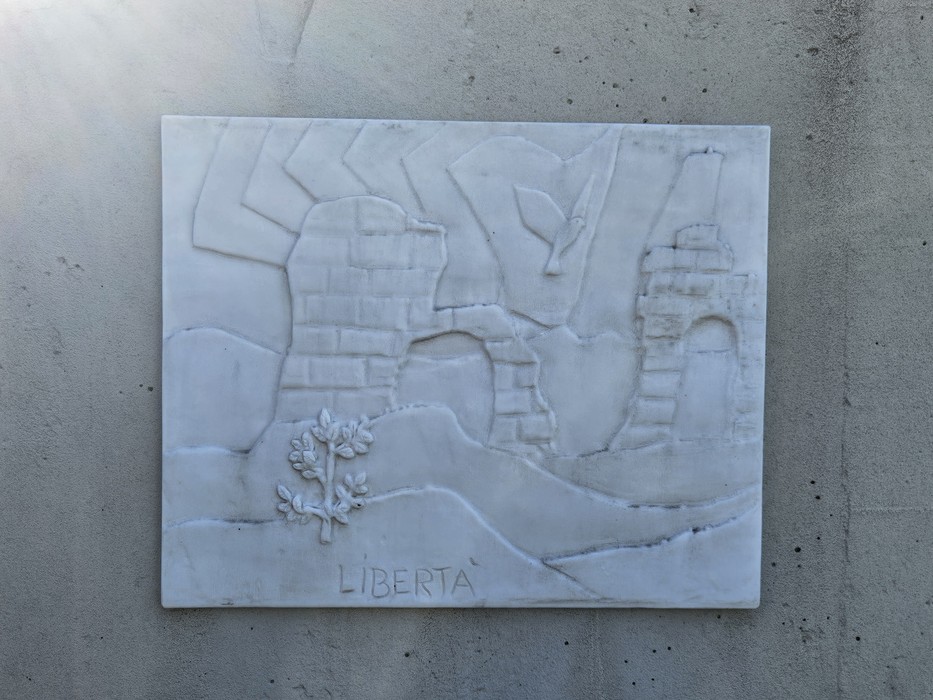 Monumento alla Resistenza con figure stilizzate e un albero, simbolo di libertà e resistenza.