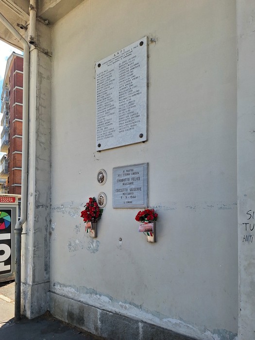 Lapide commemorativa ai caduti e partigiani di Madonna di Campagna, con fiori adorni.