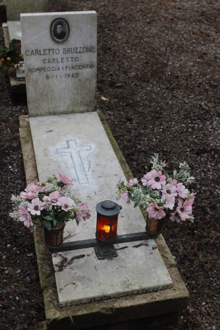 Tomba di Carletto Bruzzone, con fiori e una lanterna, in memoria dei caduti per la libertà.