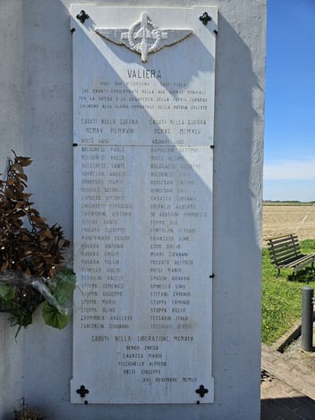 Monumento ai Caduti di Valliera, con iscrizioni commemorative e decorazioni floreali. Ambientazione rurale circostante.