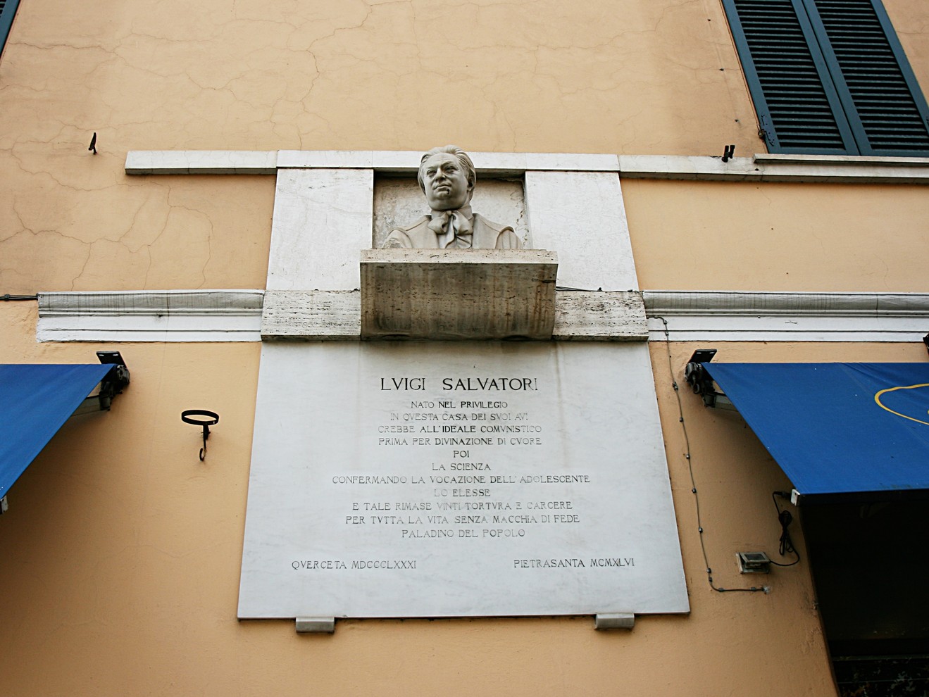 Lapide commemorativa dedicata a Livio Salvatori, situata su una facciata di edificio.