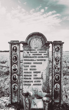 Monumento commemorativo dedicato ai lavoratori uccisi, con fotografie e nomi delle vittime.