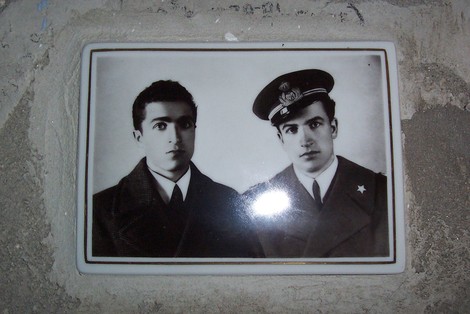 Due uomini in uniforme, in bianco e nero, commemorano i fratelli Bimbi nella Cappella dedicata.