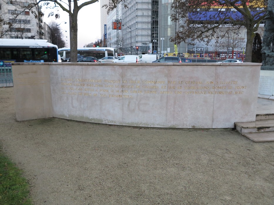 Statua commemorativa dedicata a Juin, situata in un'area pubblica, con testo inscrito su una base in pietra.