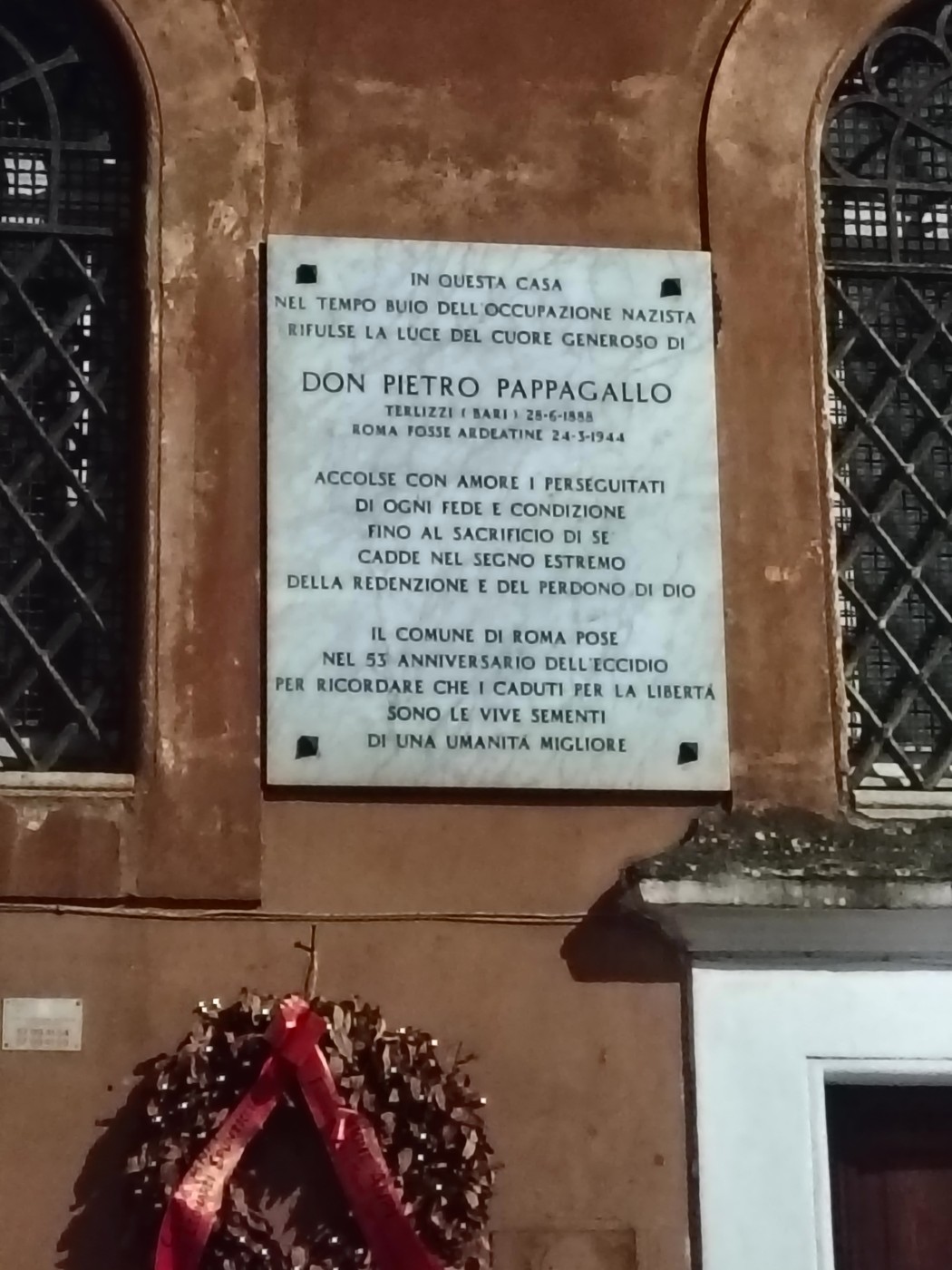 Lapide commemorativa dedicata a Don Pietro Pappagallo, vieni visitata in un contesto storico di resistenza.