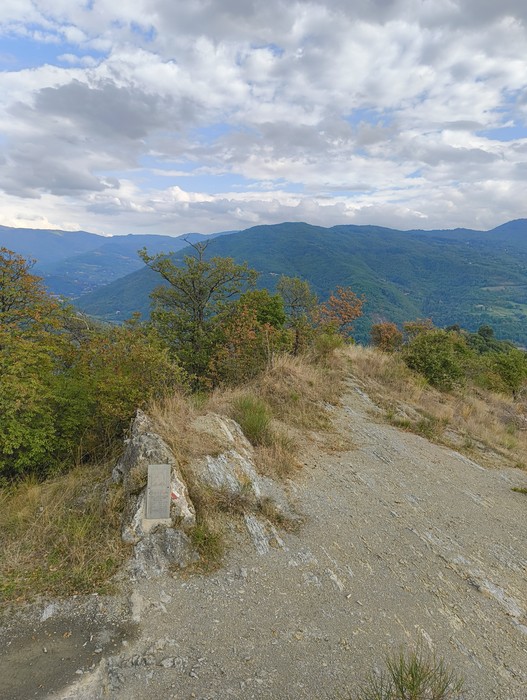 Lapide commemorativa per l'eccidio di Capraia, immersa nel paesaggio montano.