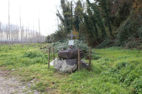 Monumento ai Guidi, composto da una croce e sassi, immerso nella natura e circondato da vegetazione.