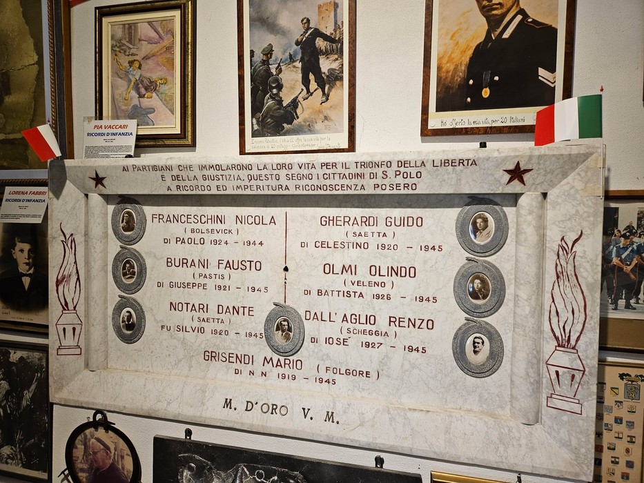 Lapide commemorativa dedicata ai caduti di San Polo, decorata con nomi e simboli patriottici.