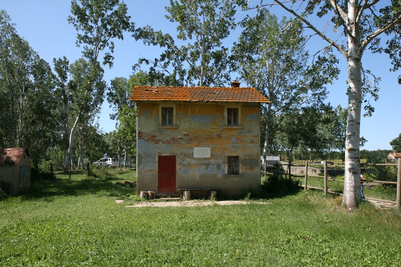 Casa storica al Casotto dei Criachi, circondata da alberi e verde, con evidenti segni del tempo.