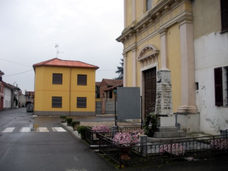 Monumento ai caduti di Cornale, situato in un'area tranquilla vicino a edifici storici e fioriere.