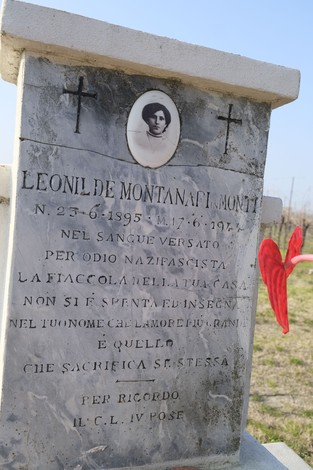 Cippo commemorativo a Montanari, dedicato a Leonildo de Montanari, con simboli religiosi e decorazioni affettive.