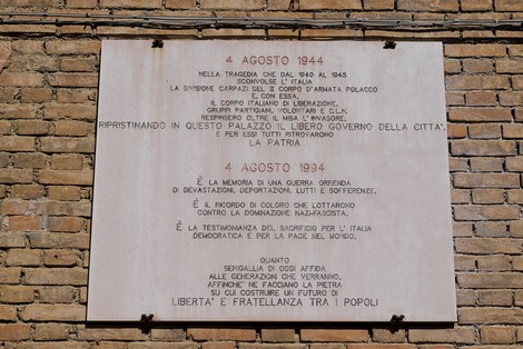 Lapide commemorativa dedicata alla Liberazione, incisa su un muro, con date significative e messaggi di memoria storica.