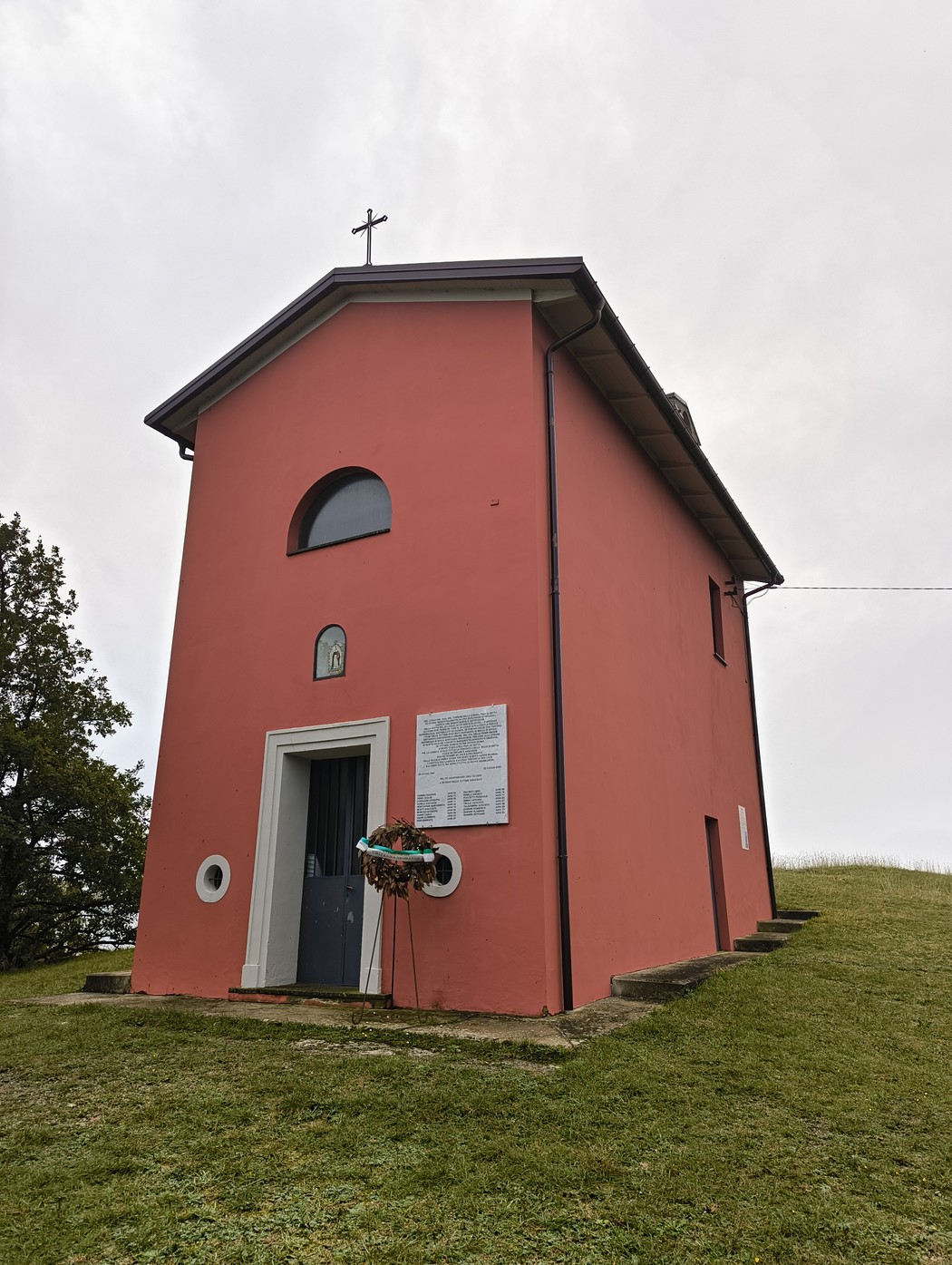 Lapide commemorativa dell'eccidio di Pian di Setta, situata vicino a una piccola chiesa.