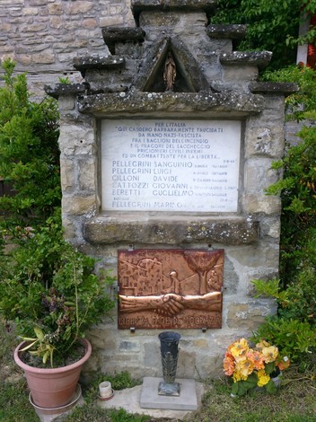 Lapide commemorativa dedicata a Pellegrini e altri, con iscrizioni e elementi decorativi significativi.