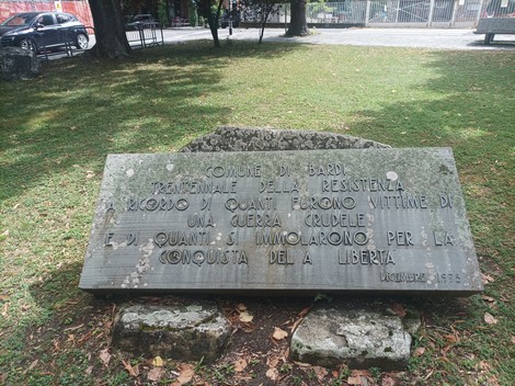 Lapide commemorativa in un parco, dedicata alle vittime della Resistenza e della guerra per la libertà.