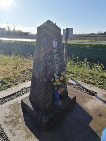 Cippo a Guidi con fiori, situato in un campo, catturato in una giornata di sole.