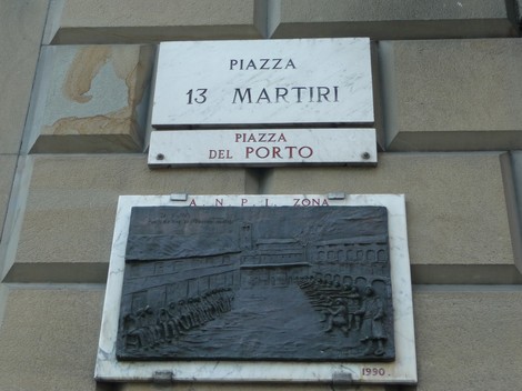 Targa commemorativa in marmo dedicata ai Tredici Martiri, situata in piazza del Porto.