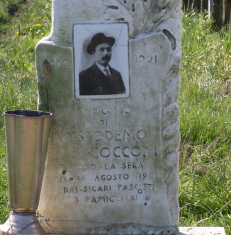 Cippo commemorativo dedicato ad Aristodemo Cocconi, situato in un contesto naturale.