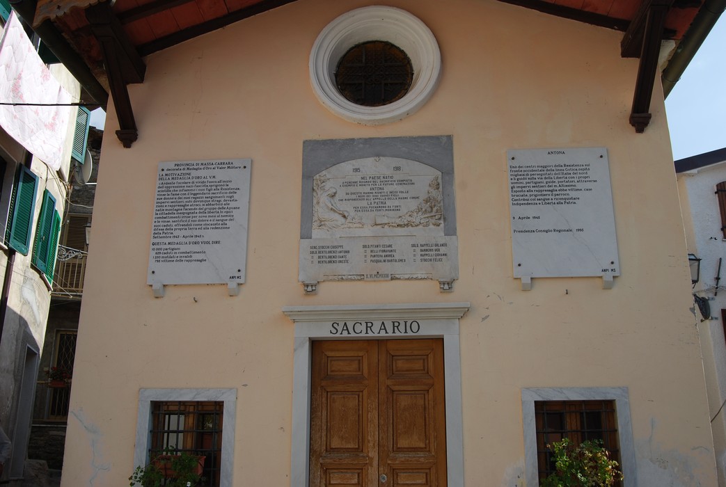 Facciata del Sacrario di Antona, memoriale in onore dei caduti, con iscrizioni commemorative sulla parete.