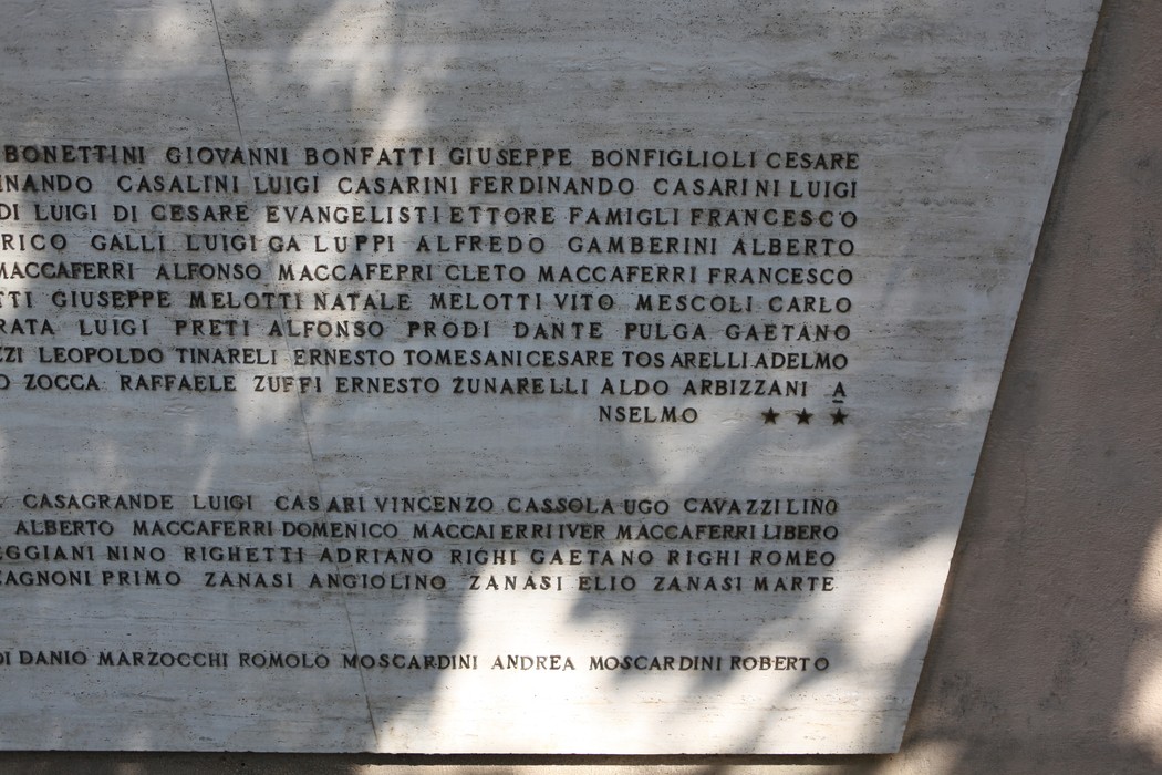 Monumento ai Caduti, commemorazione di eroi con nomi incisi su pietra in un contesto solenne e rispettoso.
