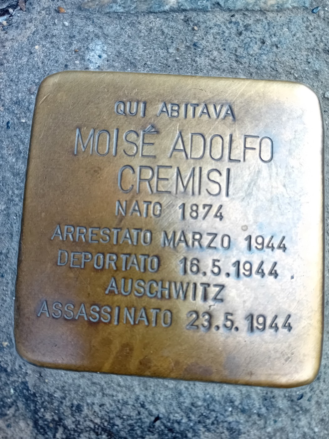 Pietra d'inciampo in ottone incassata nel selciato, con iscrizione dedicata a Cremisi Moisé Adolfo.