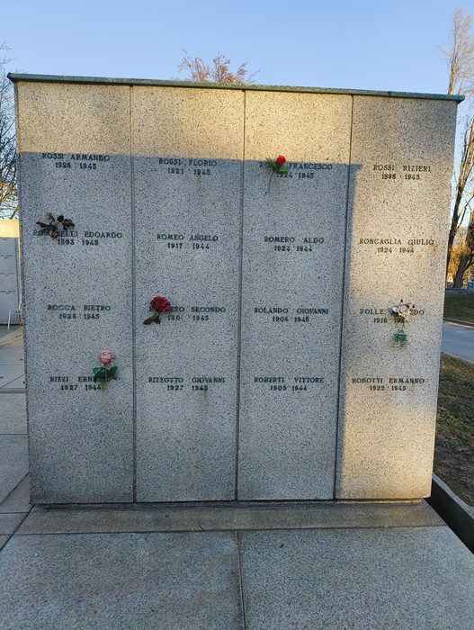 Monumento commemorativo nel Campo della Gloria, con nomi e fiori commemorativi in ricordo dei defunti.
