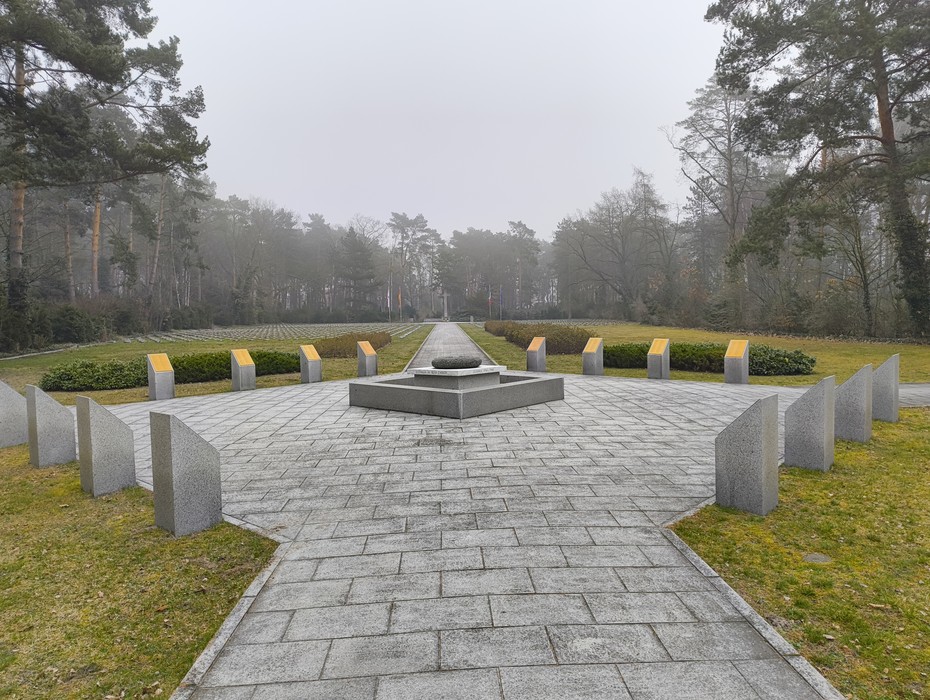Cimitero militare italiano di Zehlendorf, con monumenti e un'ampia area verde, immerso nella nebbia.