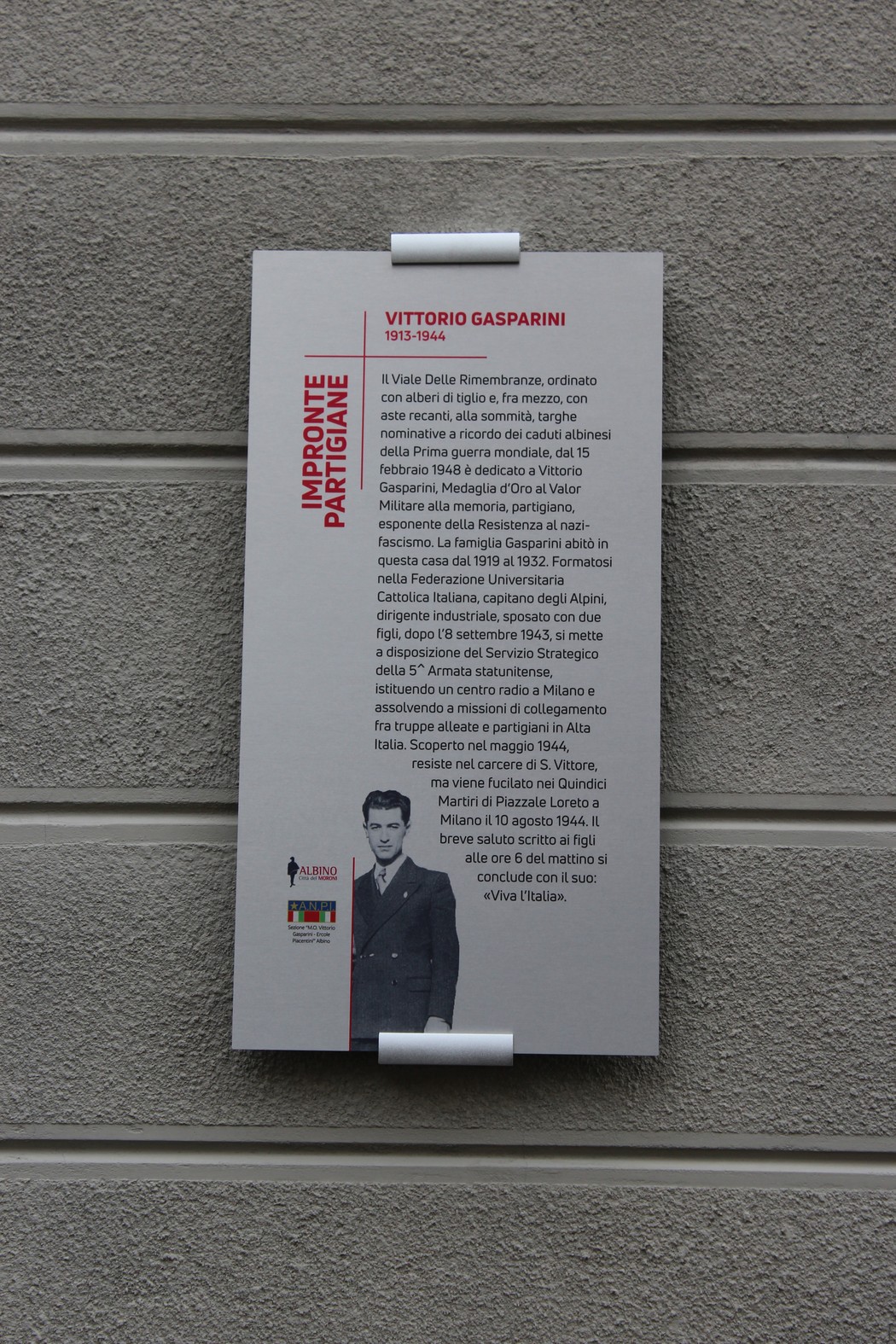 Immagine di un'informativa su Vittorio Gasparini, partigiano, affissa su una parete. Contesto storico e commemorativo.