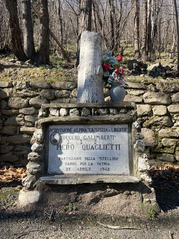Cippo commemorativo dedicato a Piero Quaglietti, partigiano, situato in un bosco.