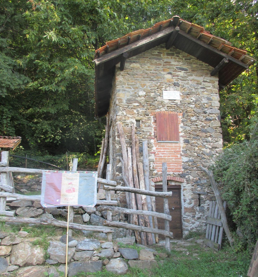 Lapide commemorativa al Pisacane, situata in un antico edificio di pietra immerso nella natura.