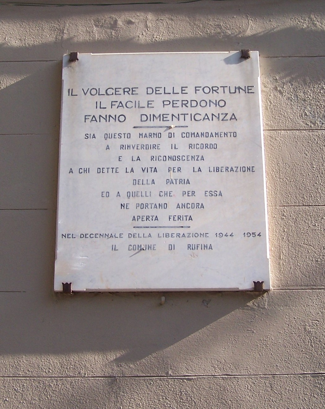 Lapide commemorativa per il decennale della liberazione, dedicata alla memoria dei caduti e al riconoscimento della patria.