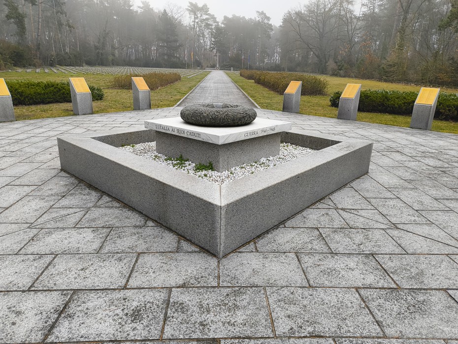 Cimitero militare italiano di Zehlendorf, area tranquilla con monumento centrale e paesaggio verde circostante.