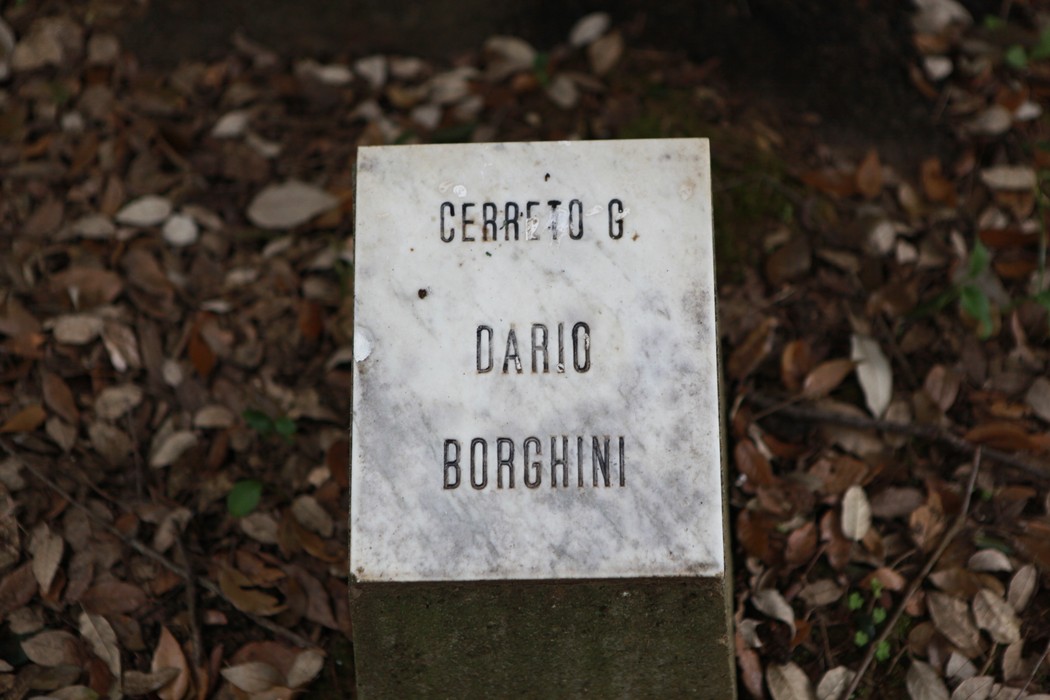 Lapide in marmo nel "Giardino della meditazione" tra foglie secche, evocando un'atmosfera di riflessione e tranquillità.