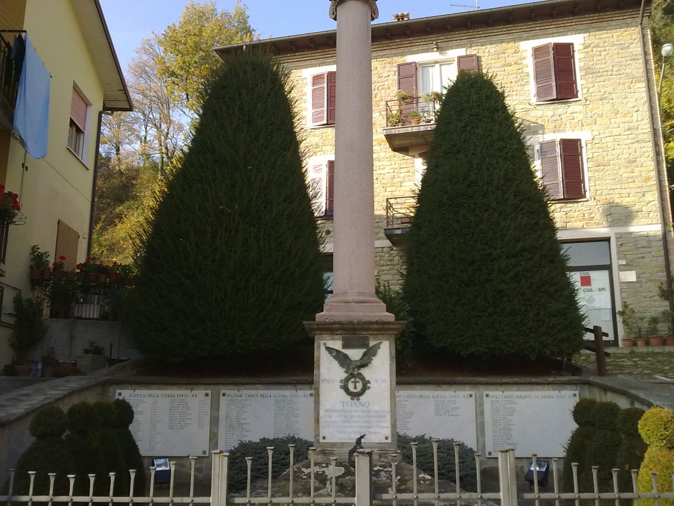 Monumento ai Caduti di Toano, commemorazione dei soldati, circondato da alberi e monumenti dedicati.