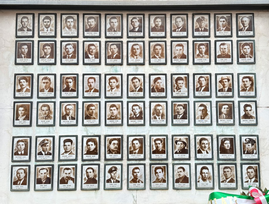Sacrario dei caduti partigiani con una serie di ritratti in bianco e nero di uomini e donne.