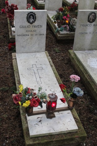 Tombe con fiori e candele, in memoria dei caduti per la Libertà, simbolo di rispetto e commemorazione.