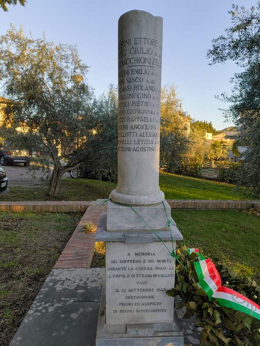 Cippo commemorativo dedicato ai caduti della Seconda Guerra Mondiale, situato in un giardino pubblico.