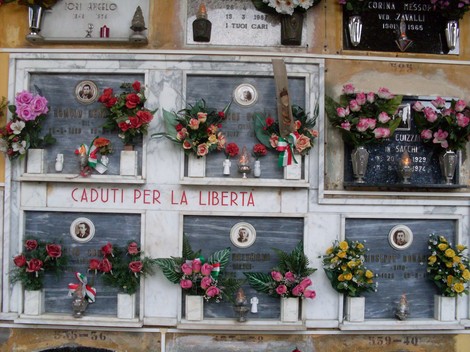 Sacrario dedicato ai caduti per la libertà, decorato con fiori e candele. Omaggio alla memoria dei valorosi.