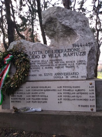 Monumento commemorativo per l'eccidio di Villa Martuzzi, con decorazioni floreali e iscrizioni in pietra.