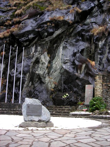 Monumento in memoria della Resistenza a Chesod, circondato da natura e simboli di lotta e libertà.