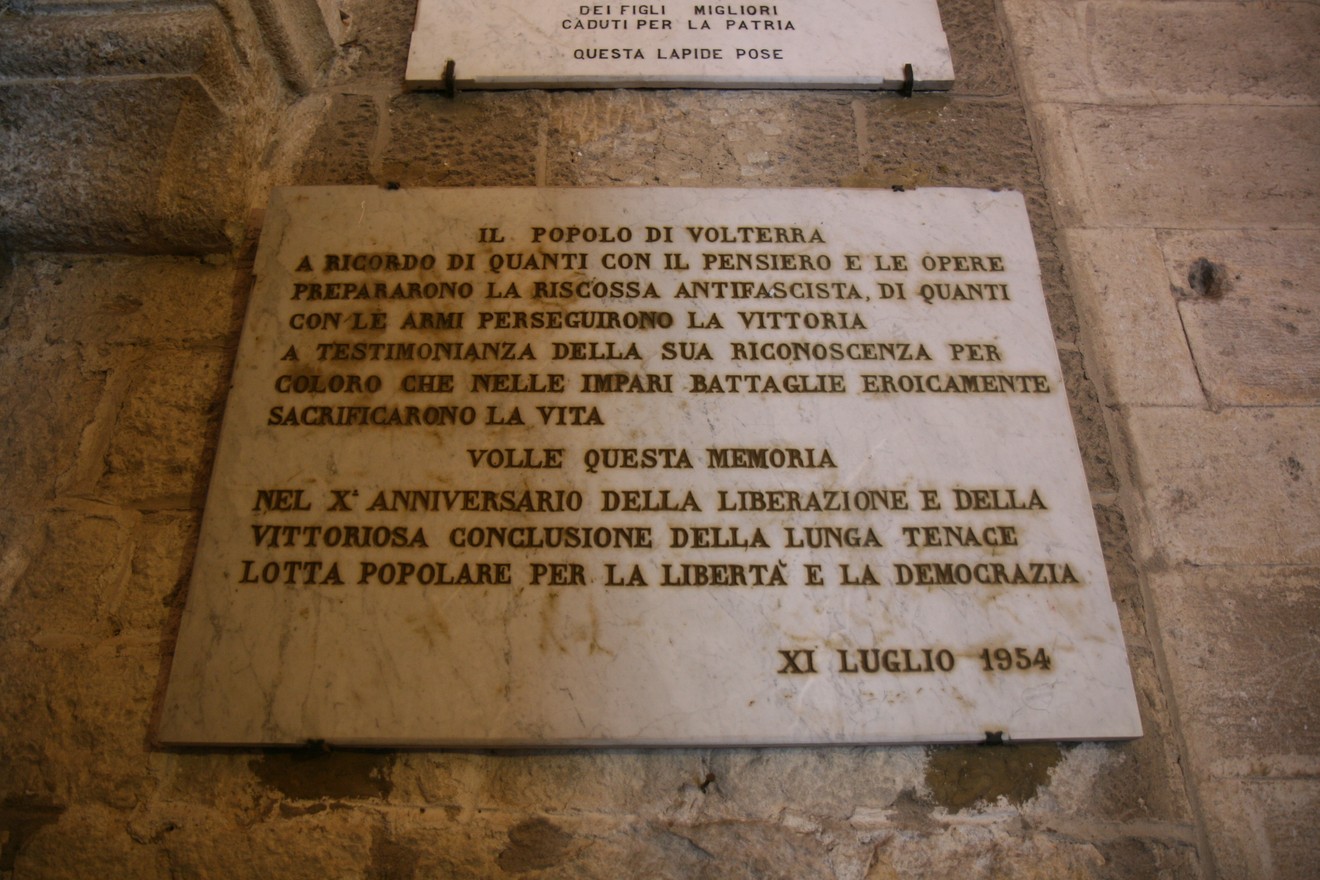 Lapide commemorativa del decennale, onora i sacrifici per la libertà e la democrazia a Volterra.